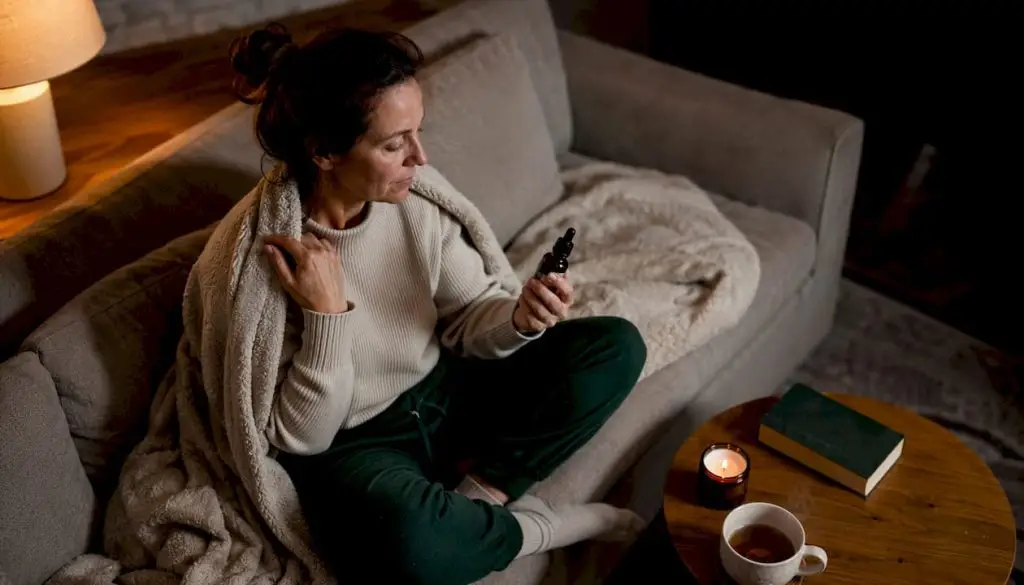 Woman holding cannabinoid sleep aid bottle in bedroom