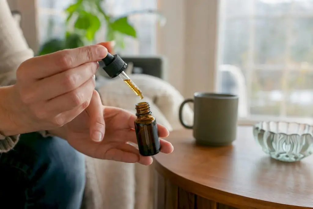 Person drawing cannabis tincture dose with dropper