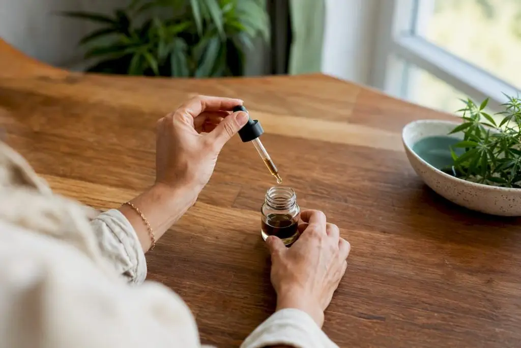 Hands pouring cannabis tincture drops