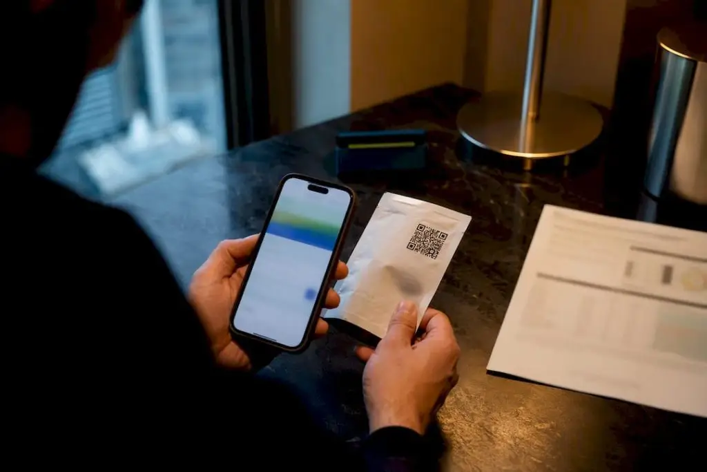 Tourist scanning cannabis QR code beside certificate