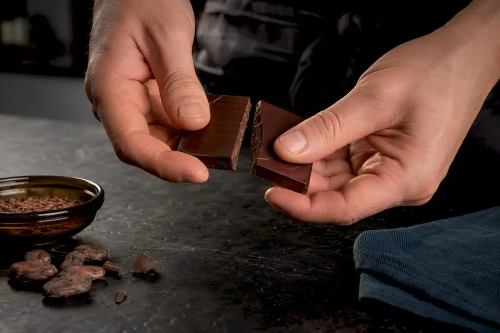 Hands breaking a sugar-free chocolate square